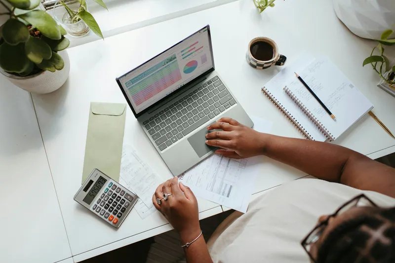 Budget figures being worked through on a laptop with a calculator